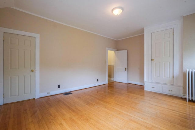 25 Oliver St, Bath, ME 04530 - unfurnished bedroom with radiator heating unit, light wood-style floors, and crown molding