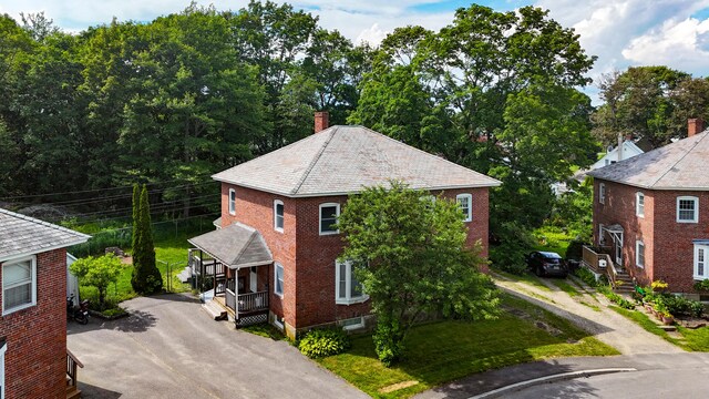 25 Oliver St, Bath, ME 04530 - view of home's exterior featuring asphalt driveway, brick siding, and a chimney