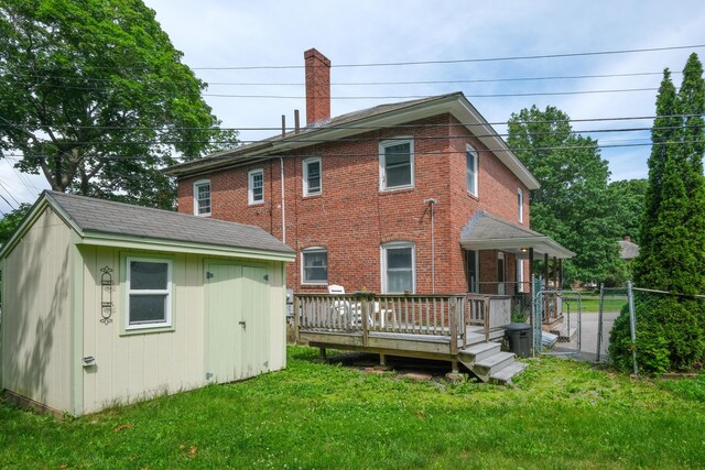 25 Oliver St, Bath, ME 04530 - rear view of house featuring a shed, a deck, brick siding, and a chimney