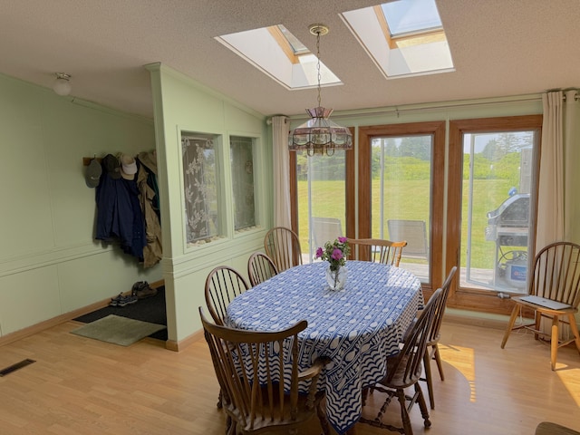8 Bar Is, Tremont, ME 04674 - dining space with vaulted ceiling, a skylight, light wood-style flooring, plenty of natural light, and ornamental molding