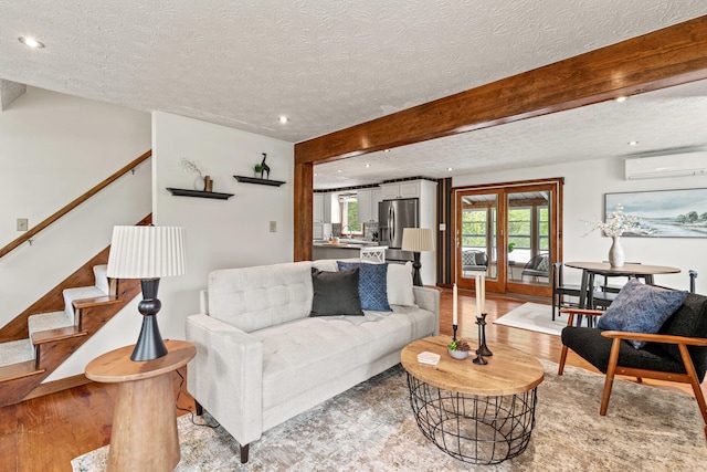 13 Wildbrook Dr, Biddeford, ME 04005 - living area featuring a textured ceiling, an AC wall unit, stairs, light wood-style flooring, and beamed ceiling