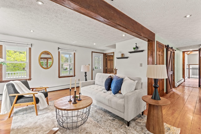 13 Wildbrook Dr, Biddeford, ME 04005 - living area featuring a textured ceiling, light wood-style flooring, baseboard heating, a barn door, and plenty of natural light