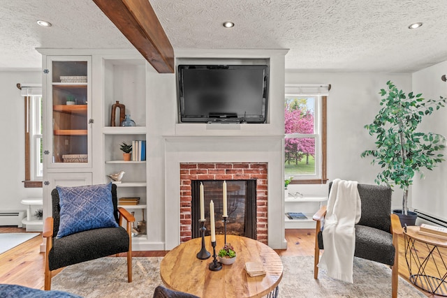 13 Wildbrook Dr, Biddeford, ME 04005 - living room with a textured ceiling, wood finished floors, a baseboard radiator, a fireplace, and recessed lighting