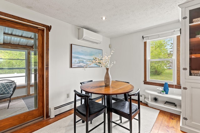 13 Wildbrook Dr, Biddeford, ME 04005 - dining area with an AC wall unit, a baseboard radiator, light wood-style flooring, and a textured ceiling