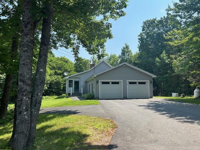 60 Dawes Rd, Dover-Foxcroft, ME 04426 - view of front of home with a garage, driveway, a front yard, and a chimney
