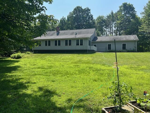 60 Dawes Rd, Dover-Foxcroft, ME 04426 - rear view of house featuring a lawn and a chimney