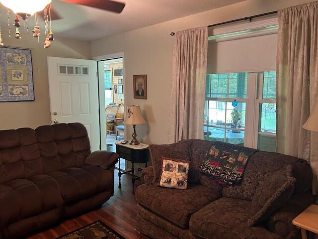 60 Dawes Rd, Dover-Foxcroft, ME 04426 - living area with wood finished floors, a ceiling fan, and a chandelier