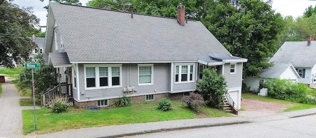 99 Gamage Ave, Auburn, ME 04210 - view of front of house featuring a chimney, a front lawn, an attached garage, and roof with shingles