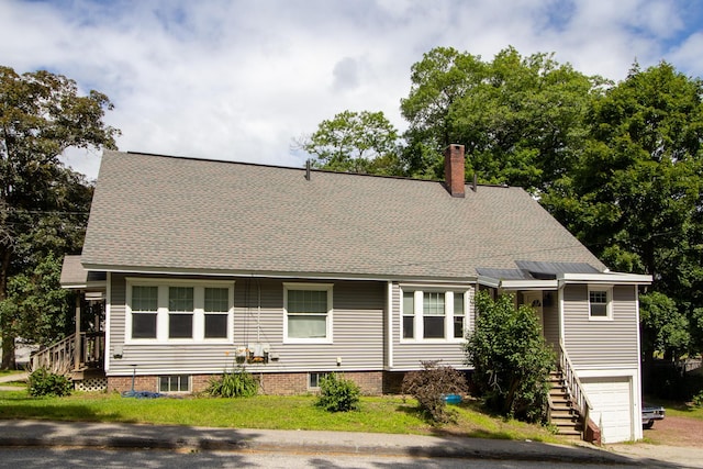99 Gamage Ave, Auburn, ME 04210 - view of front facade with stairway, a garage, a chimney, and a shingled roof