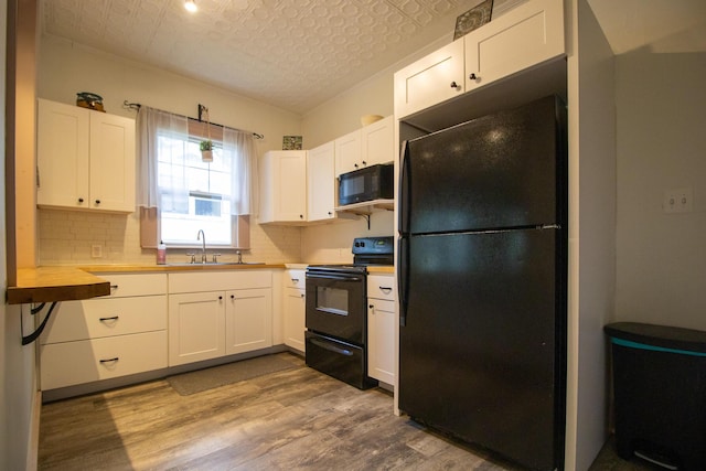 99 Gamage Ave, Auburn, ME 04210 - kitchen with black appliances, an ornate ceiling, dark wood-style floors, white cabinetry, and backsplash