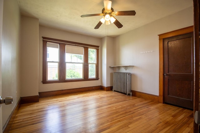 99 Gamage Ave, Auburn, ME 04210 - unfurnished room featuring radiator, light wood finished floors, and a ceiling fan