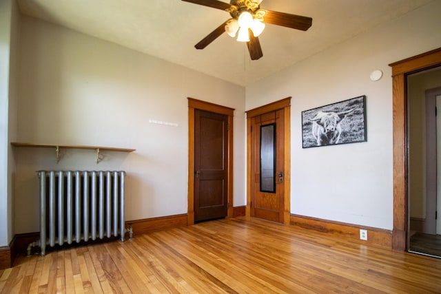 99 Gamage Ave, Auburn, ME 04210 - unfurnished living room with radiator, light wood-type flooring, and ceiling fan