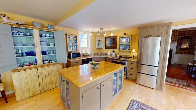 12 Center St, Machias, ME 04654 - kitchen with black appliances, butcher block counters, light wood-style flooring, and a center island