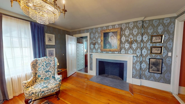12 Center St, Machias, ME 04654 - sitting room with hardwood / wood-style floors, a chandelier, wallpapered walls, a fireplace with flush hearth, and ornamental molding