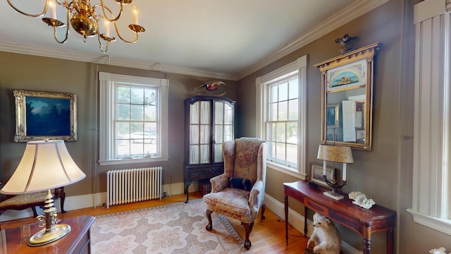 12 Center St, Machias, ME 04654 - living area with radiator heating unit, plenty of natural light, a chandelier, wood finished floors, and crown molding