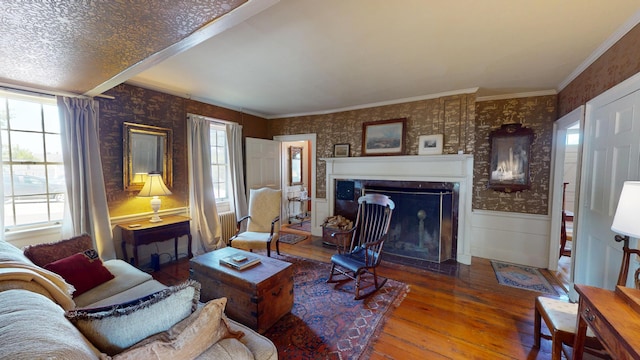 12 Center St, Machias, ME 04654 - living room with wood-type flooring, wallpapered walls, a fireplace with flush hearth, a wainscoted wall, and ornamental molding