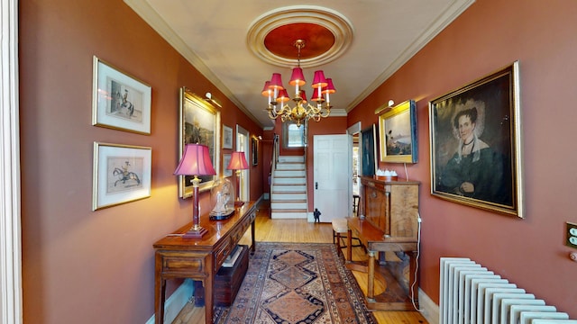 12 Center St, Machias, ME 04654 - hallway featuring radiator heating unit, a chandelier, wood finished floors, crown molding, and stairway