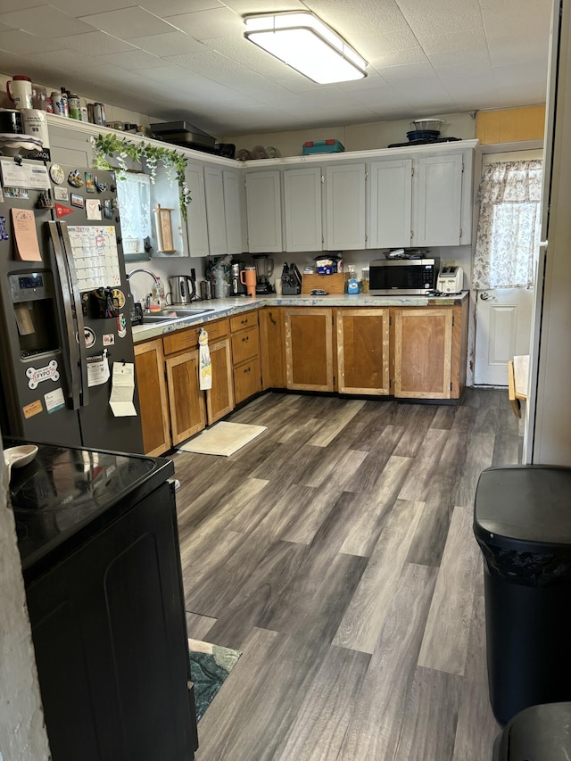 293 Grove St, Bangor, ME 04401 - kitchen featuring stainless steel appliances, light countertops, dark wood finished floors, and brown cabinets