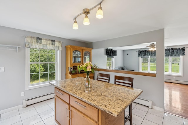 19 Straw Rd, Gorham, ME 04038 - kitchen with baseboard heating, light tile patterned floors, and a breakfast bar