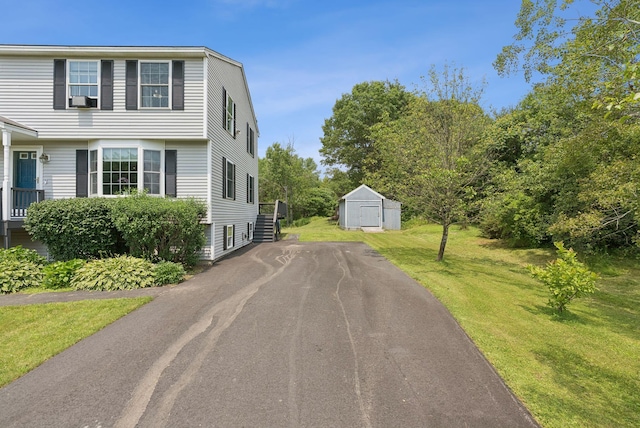 19 Straw Rd, Gorham, ME 04038 - view of home's exterior with asphalt driveway, a storage shed, and a yard