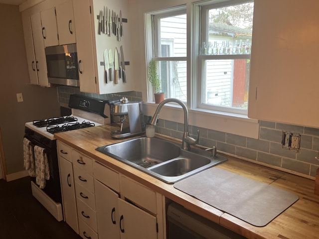 16 N Main St, Morrill, ME 04952 - kitchen featuring stainless steel microwave, gas range oven, wood counters, white cabinetry, and dishwashing machine