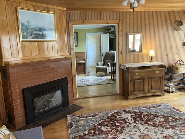 16 N Main St, Morrill, ME 04952 - living room with light wood-type flooring, wooden walls, and a fireplace