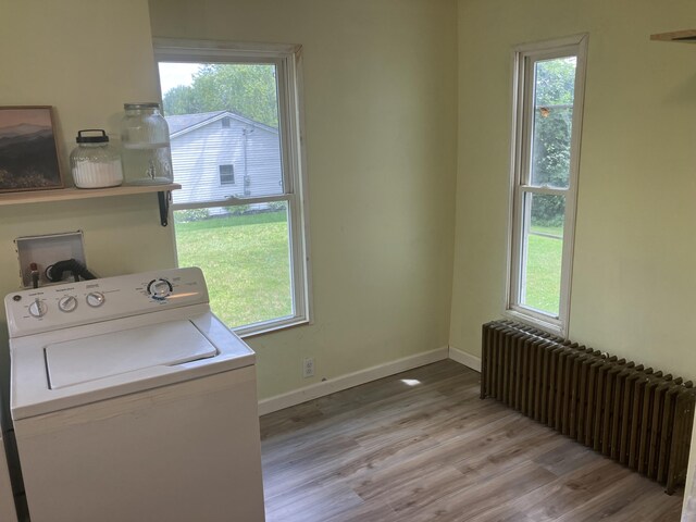 16 N Main St, Morrill, ME 04952 - laundry area with washer / dryer, radiator heating unit, light wood-type flooring, and healthy amount of natural light