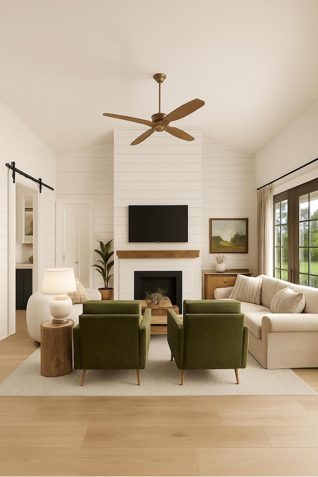 2 Moxie Ln, Biddeford, ME 04005 - living room with vaulted ceiling, wood finished floors, ceiling fan, a barn door, and a fireplace