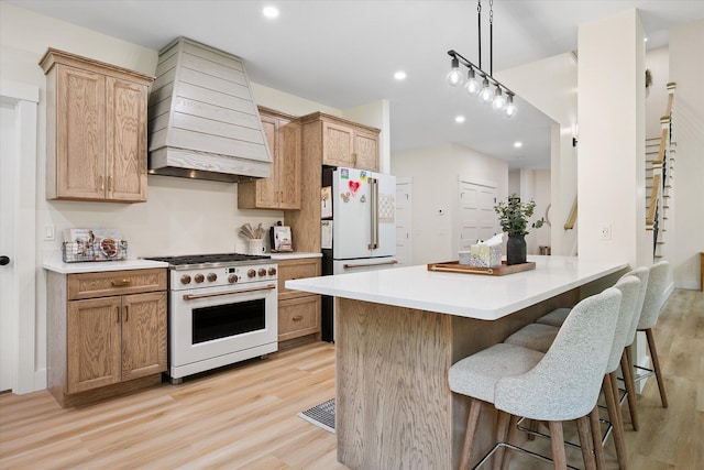 27 Meadow View Dr, Readfield, ME 04355 - kitchen with white appliances, custom exhaust hood, light wood-style flooring, a breakfast bar, and light countertops
