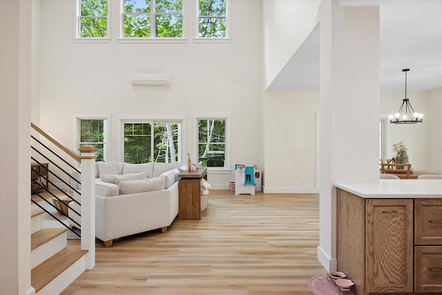 27 Meadow View Dr, Readfield, ME 04355 - living area featuring a high ceiling, stairs, light wood-style flooring, a chandelier, and an AC wall unit