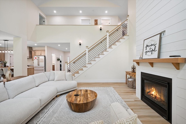 27 Meadow View Dr, Readfield, ME 04355 - living area with light wood finished floors, stairway, a large fireplace, recessed lighting, and a high ceiling