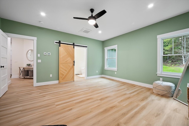 27 Meadow View Dr, Readfield, ME 04355 - unfurnished bedroom featuring light wood-style flooring, a barn door, recessed lighting, connected bathroom, and a ceiling fan