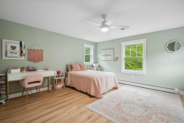 27 Meadow View Dr, Readfield, ME 04355 - bedroom featuring a baseboard heating unit, multiple windows, wood finished floors, and a ceiling fan