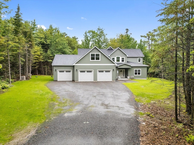 27 Meadow View Dr, Readfield, ME 04355 - view of front facade featuring a front lawn, asphalt driveway, a garage, board and batten siding, and a shingled roof