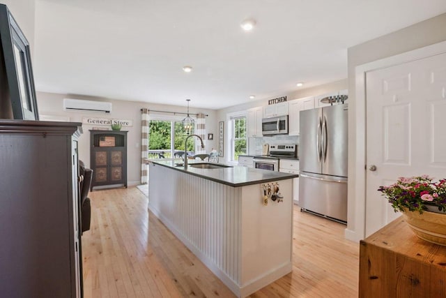 136-138 Blue Spruce Farm Rd, Westbrook, ME 04092 - kitchen featuring appliances with stainless steel finishes, a wall unit AC, light wood-style flooring, dark countertops, and recessed lighting