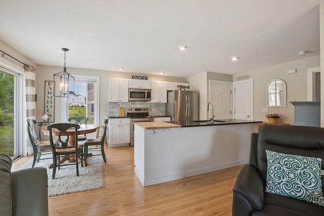 136-138 Blue Spruce Farm Rd, Westbrook, ME 04092 - kitchen featuring appliances with stainless steel finishes, open floor plan, butcher block counters, backsplash, and light wood-style flooring