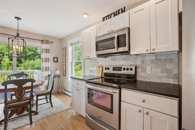 136-138 Blue Spruce Farm Rd, Westbrook, ME 04092 - kitchen with stainless steel appliances, dark countertops, light wood-type flooring, a chandelier, and tasteful backsplash