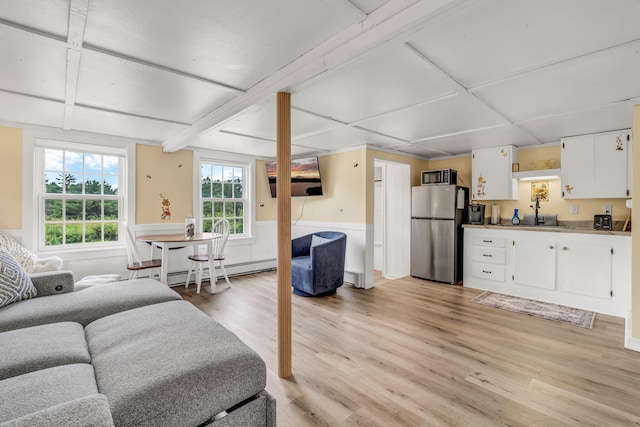 1511 Alna Rd, Alna, ME 04535 - living room with a baseboard radiator, light wood-style floors, a wainscoted wall, and beamed ceiling
