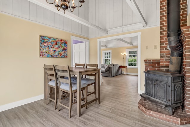1511 Alna Rd, Alna, ME 04535 - dining space featuring a wood stove, a chandelier, light wood finished floors, and beamed ceiling