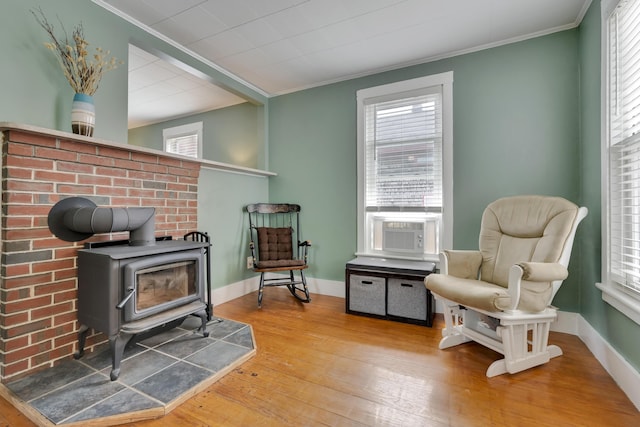 12 Maple St, Bath, ME 04530 - sitting room with hardwood / wood-style flooring, crown molding, plenty of natural light, and a wood stove