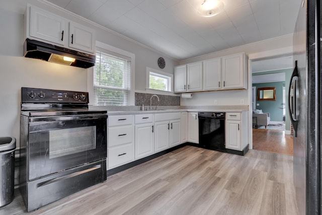 12 Maple St, Bath, ME 04530 - kitchen with black appliances, under cabinet range hood, light wood finished floors, ornamental molding, and white cabinets
