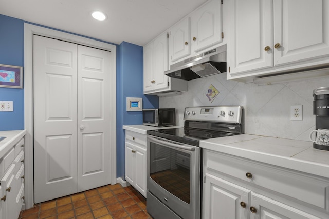 191 E Grand Ave Unit 506, Old Orchard Beach, ME 04064 - kitchen with under cabinet range hood, stainless steel appliances, white cabinetry, light countertops, and recessed lighting