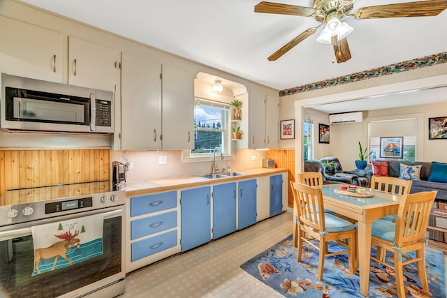 233 Northern Ave, Augusta, ME 04330 - kitchen featuring stainless steel microwave, oven, blue cabinets, open floor plan, and a wall mounted air conditioner