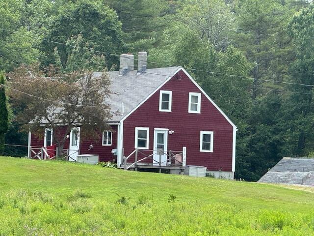 152 Cross Rd, Alna, ME 04535 - rear view of house with a chimney, a lawn, a forest view, and roof with shingles