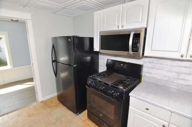 56 Holyoke St, Brewer, ME 04412 - kitchen with black appliances, white cabinets, light countertops, tasteful backsplash, and wainscoting