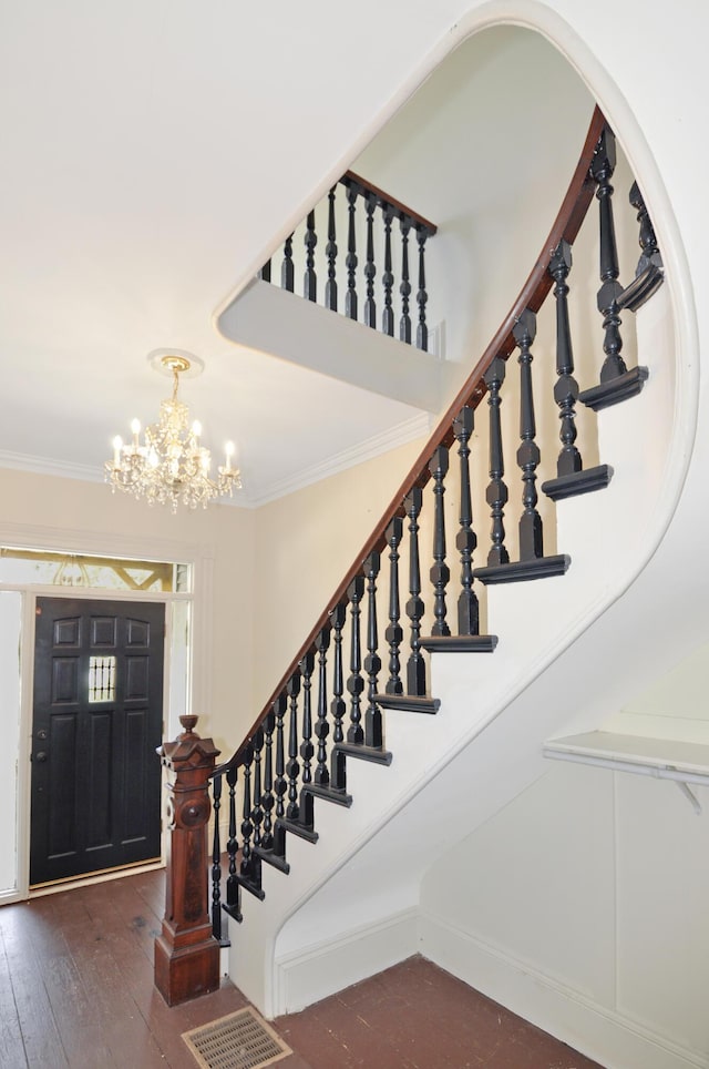 56 Holyoke St, Brewer, ME 04412 - stairway with crown molding, a chandelier, and hardwood / wood-style floors