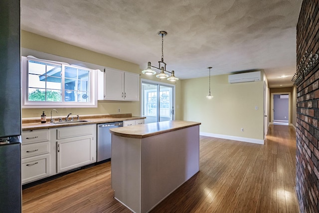 704 Brighton Hill Rd, Minot, ME 04258 - kitchen with stainless steel dishwasher, an AC wall unit, white cabinetry, dark wood finished floors, and freestanding refrigerator