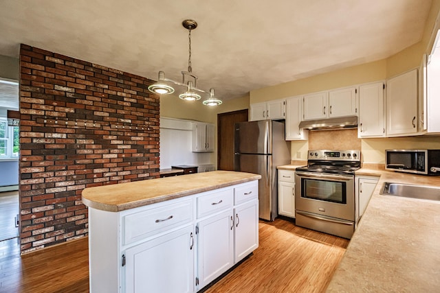 704 Brighton Hill Rd, Minot, ME 04258 - kitchen featuring appliances with stainless steel finishes, under cabinet range hood, light wood-style flooring, light countertops, and white cabinetry