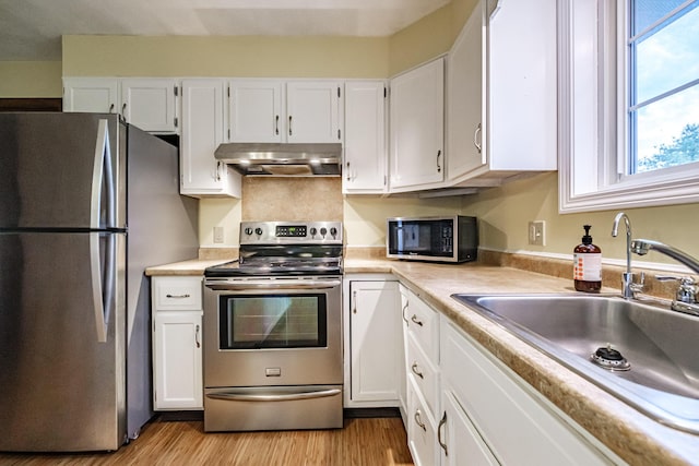 704 Brighton Hill Rd, Minot, ME 04258 - kitchen featuring stainless steel appliances, range hood, light wood finished floors, light countertops, and white cabinetry