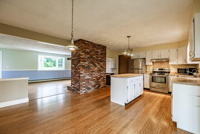 704 Brighton Hill Rd, Minot, ME 04258 - kitchen with appliances with stainless steel finishes, baseboard heating, a kitchen island, white cabinetry, and light countertops
